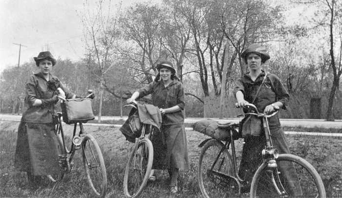 Trois soeurs à bicyclette, avec paquets à l'avant ou à l'arrière
